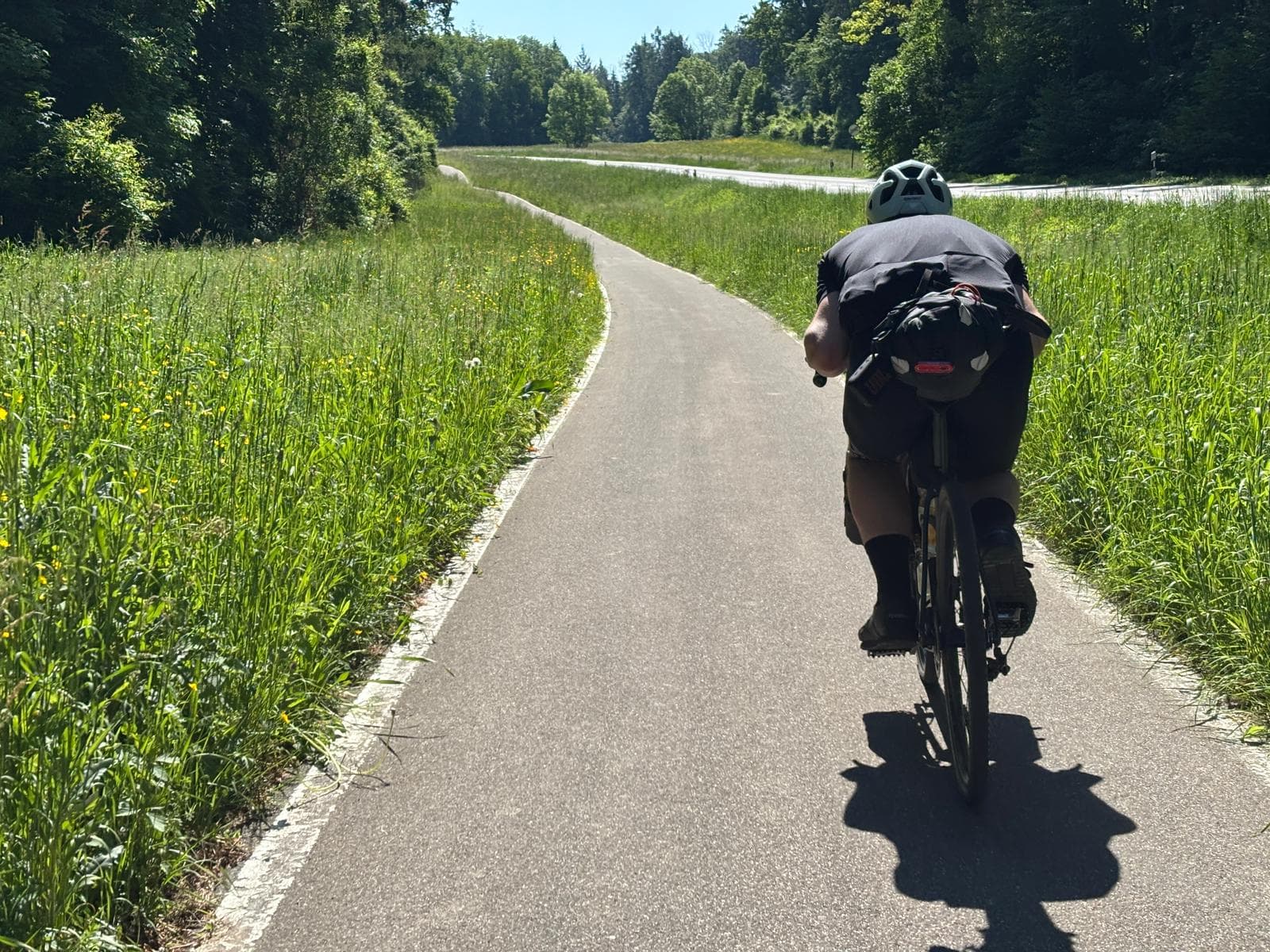 Bepacktes Gravelbike in Aero-Position auf Radweg am Bodensee, 2025.